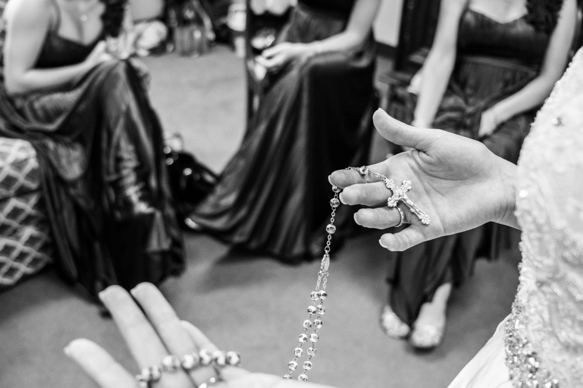 Bride praying the rosary while getting ready for wedding ceremony