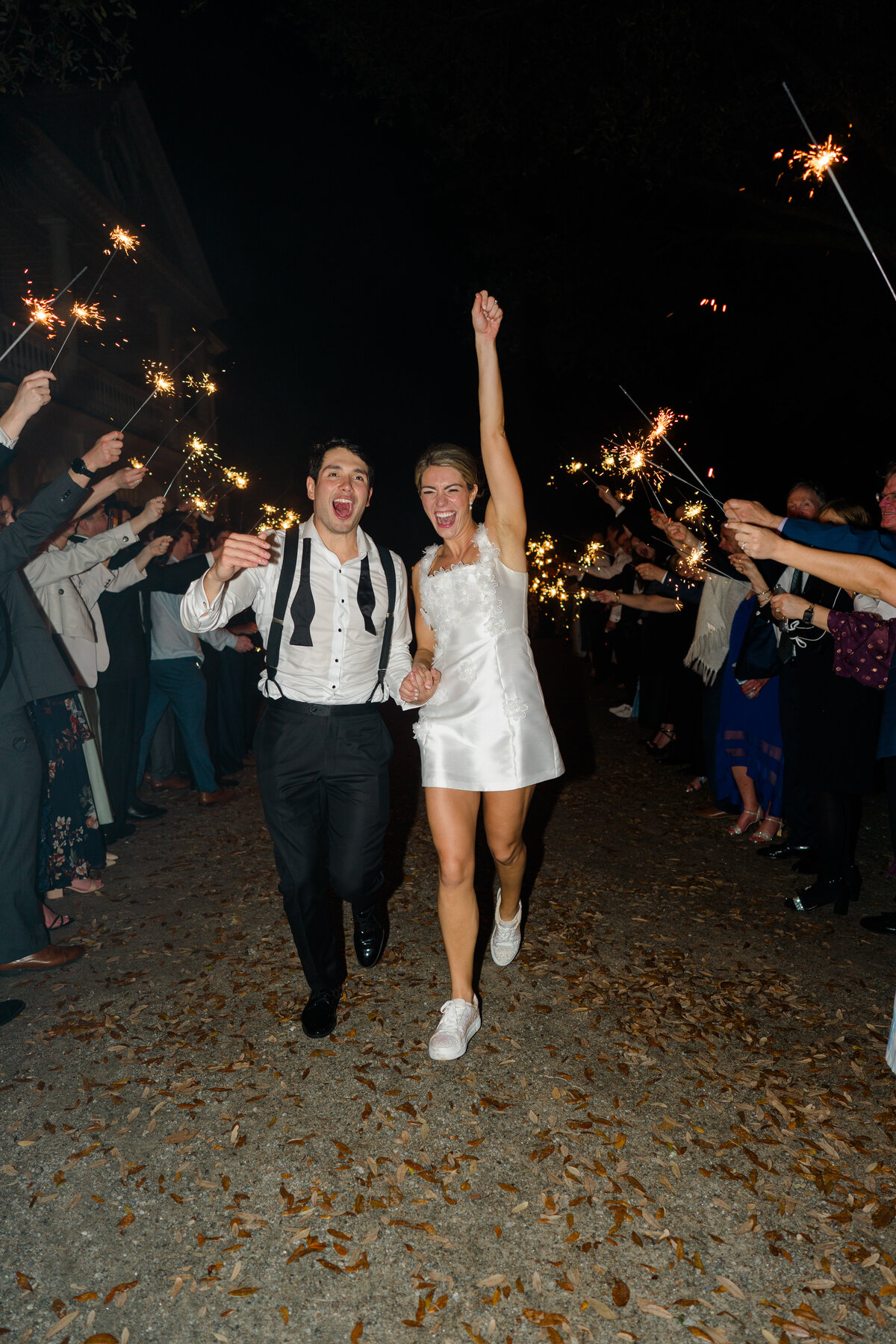 Sparkler exit at Lowndes Grove. Bride and groom celebrate while running through the crowd after epic party wedding reception with live band.
