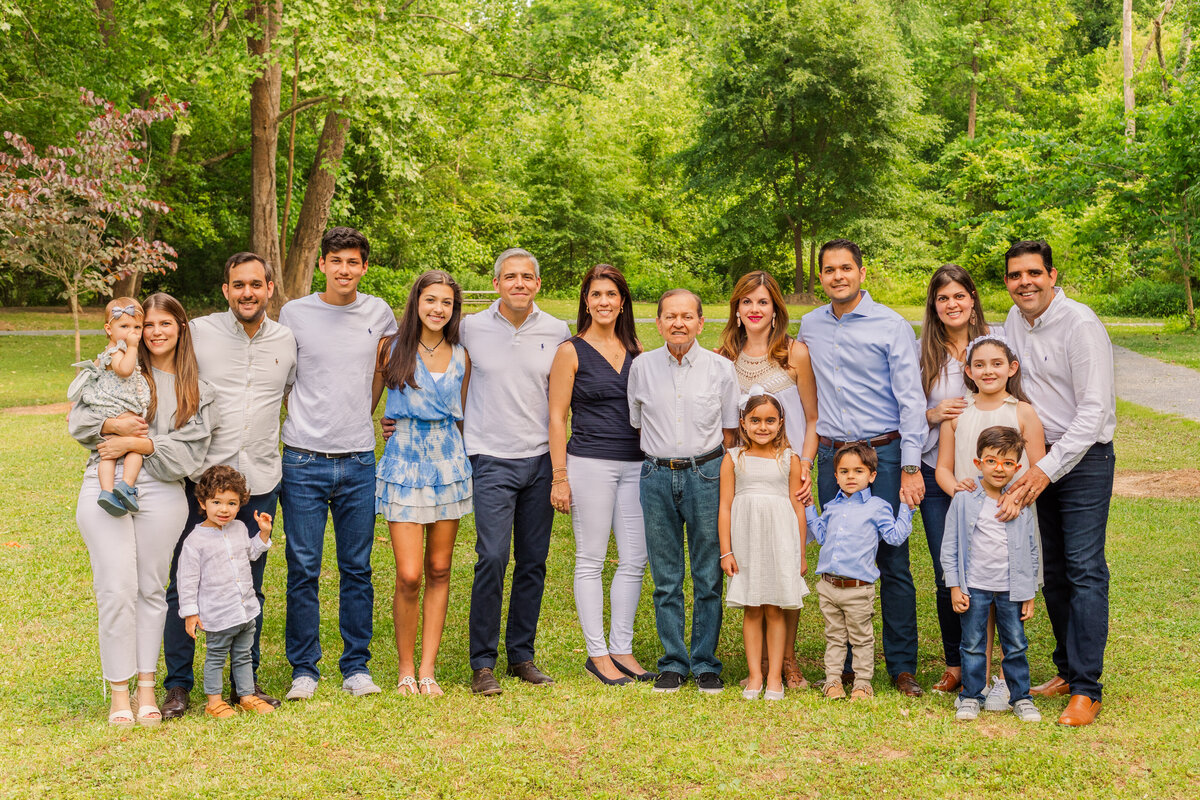 Extended multi generation family wearing coordinated white and blue outfits in a Atlanta Sandy Spring park by Laure Photography