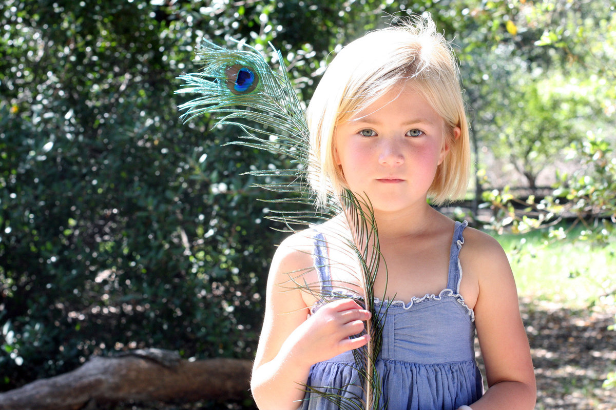 little girl with peacock feather