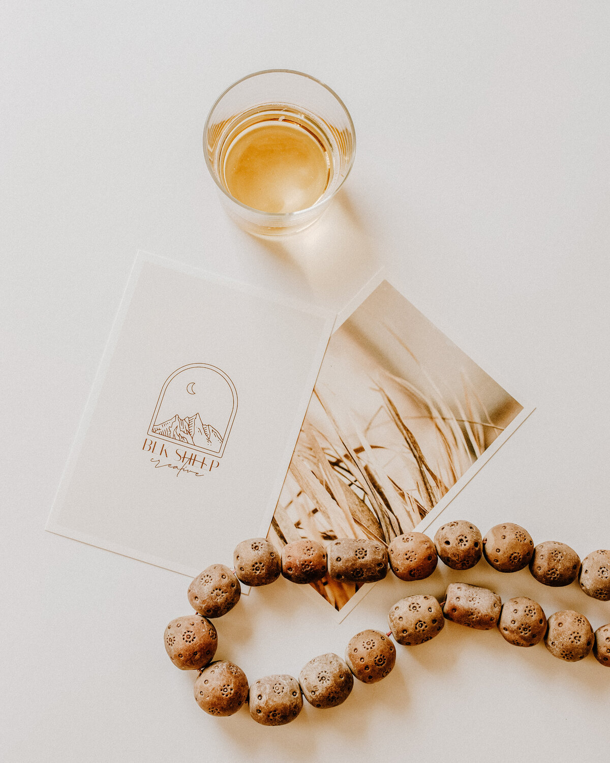 whiskey with bead and graphic prints flatlay