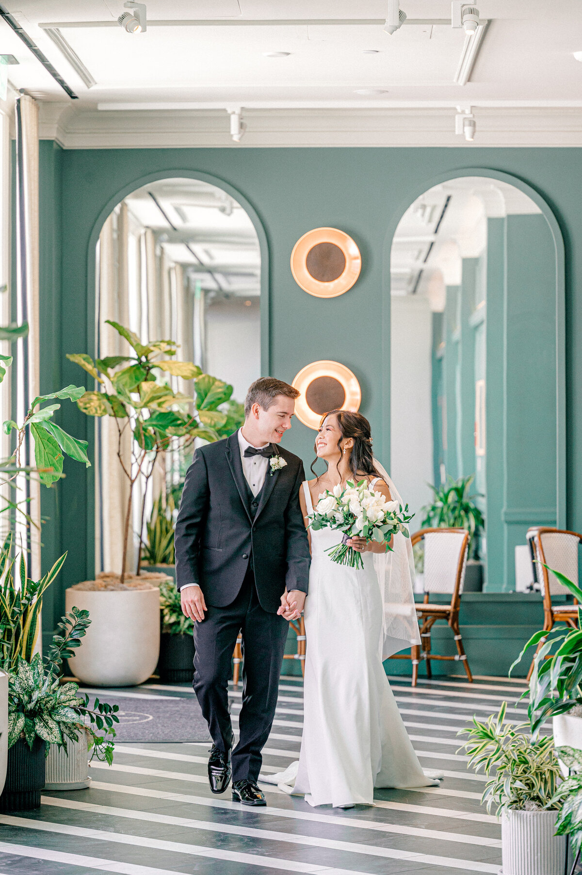 bride and groom walk the hallway at the Cottonwood Hotel Omaha