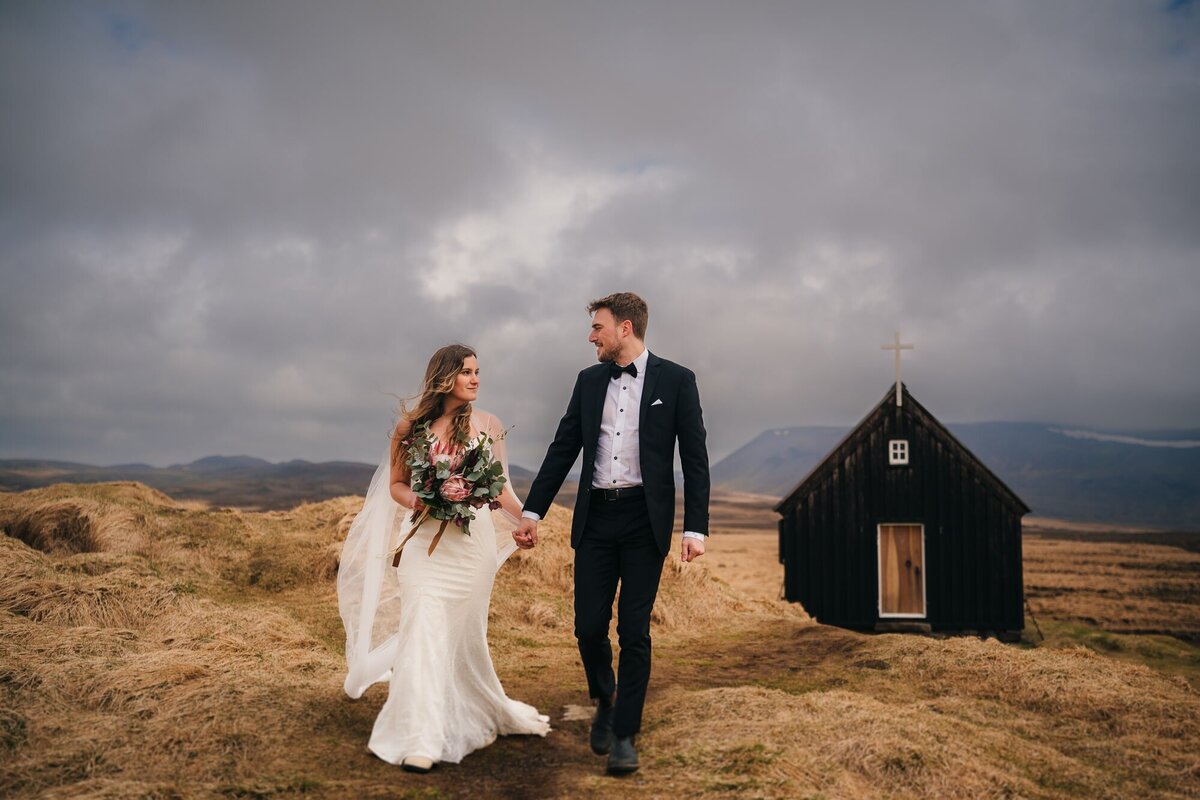 This couple walks towards their future, a quaint Icelandic church standing witness to the romance unfolding in the scenic beauty around.