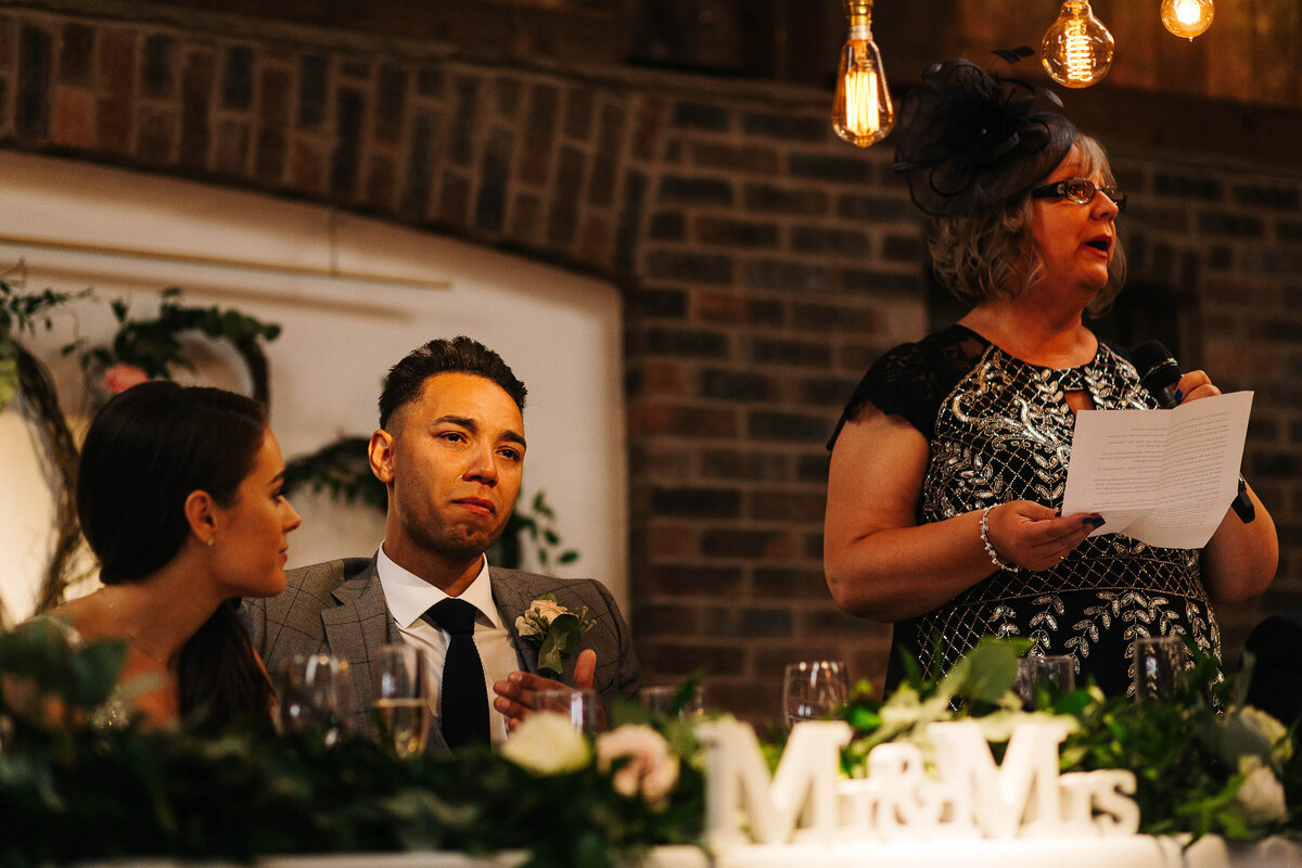 An emotional groom as his mum reads a speech at his wedding
