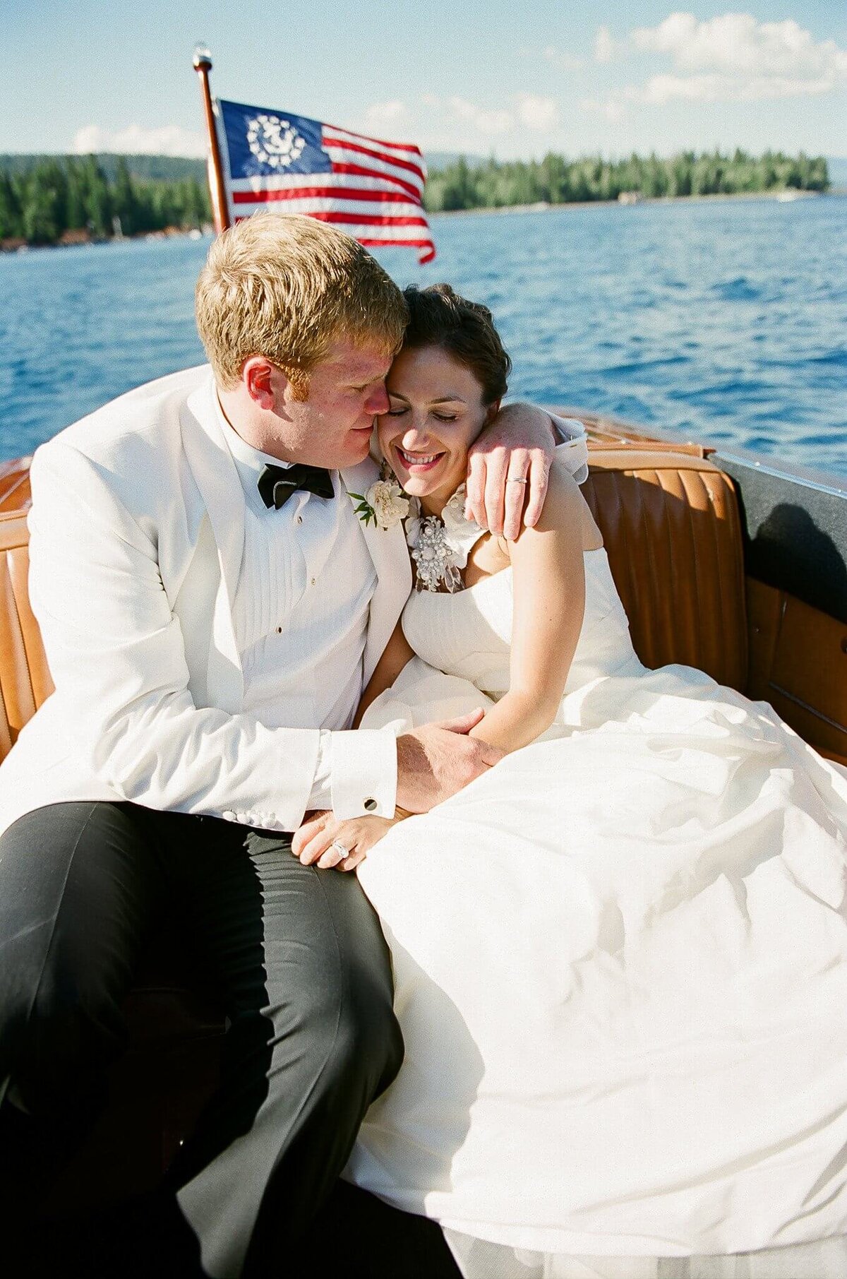 couple hugging just married on vintage boat in Lake Tahoe