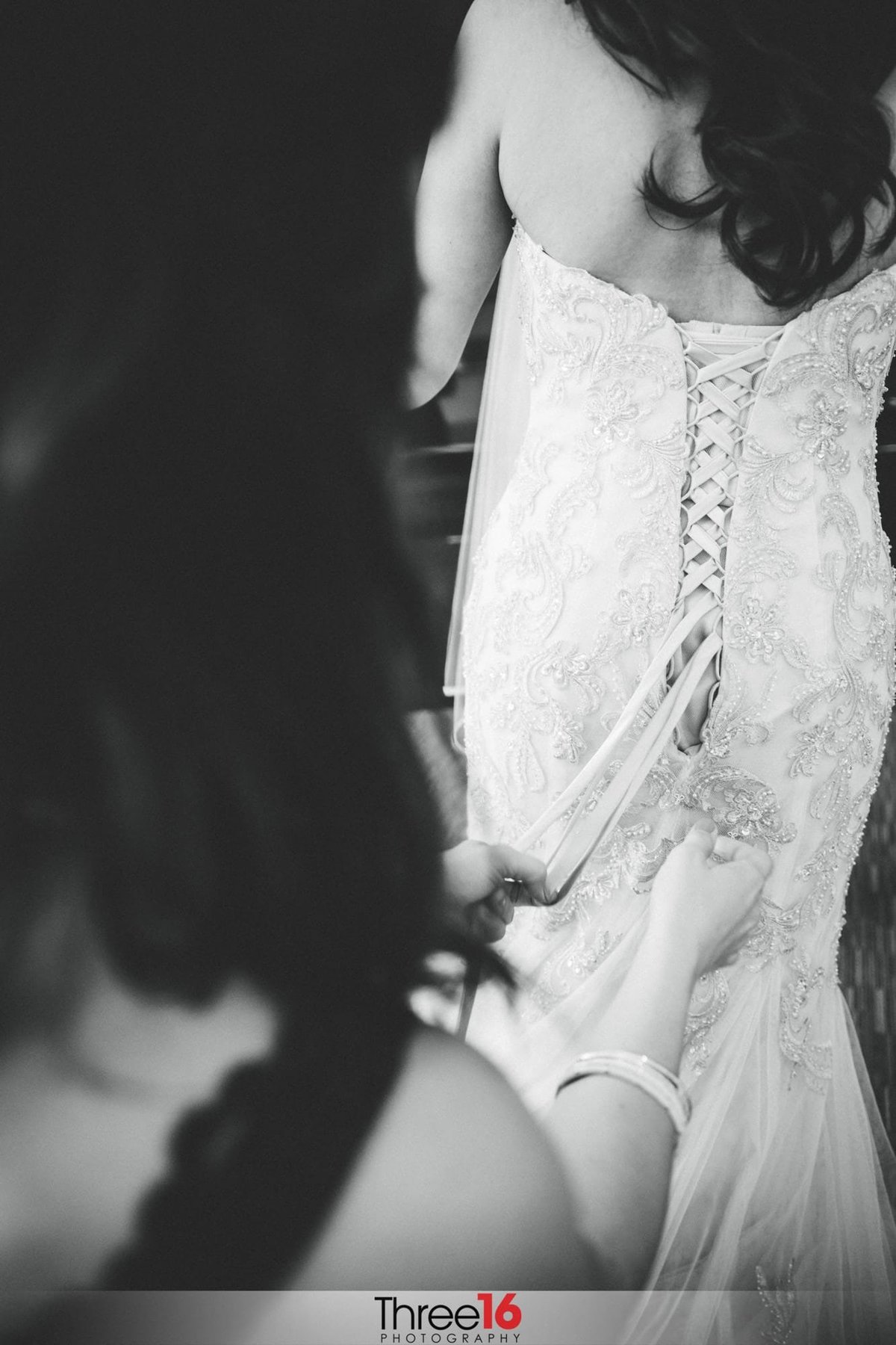 Bride having her wedding gown buttoned up
