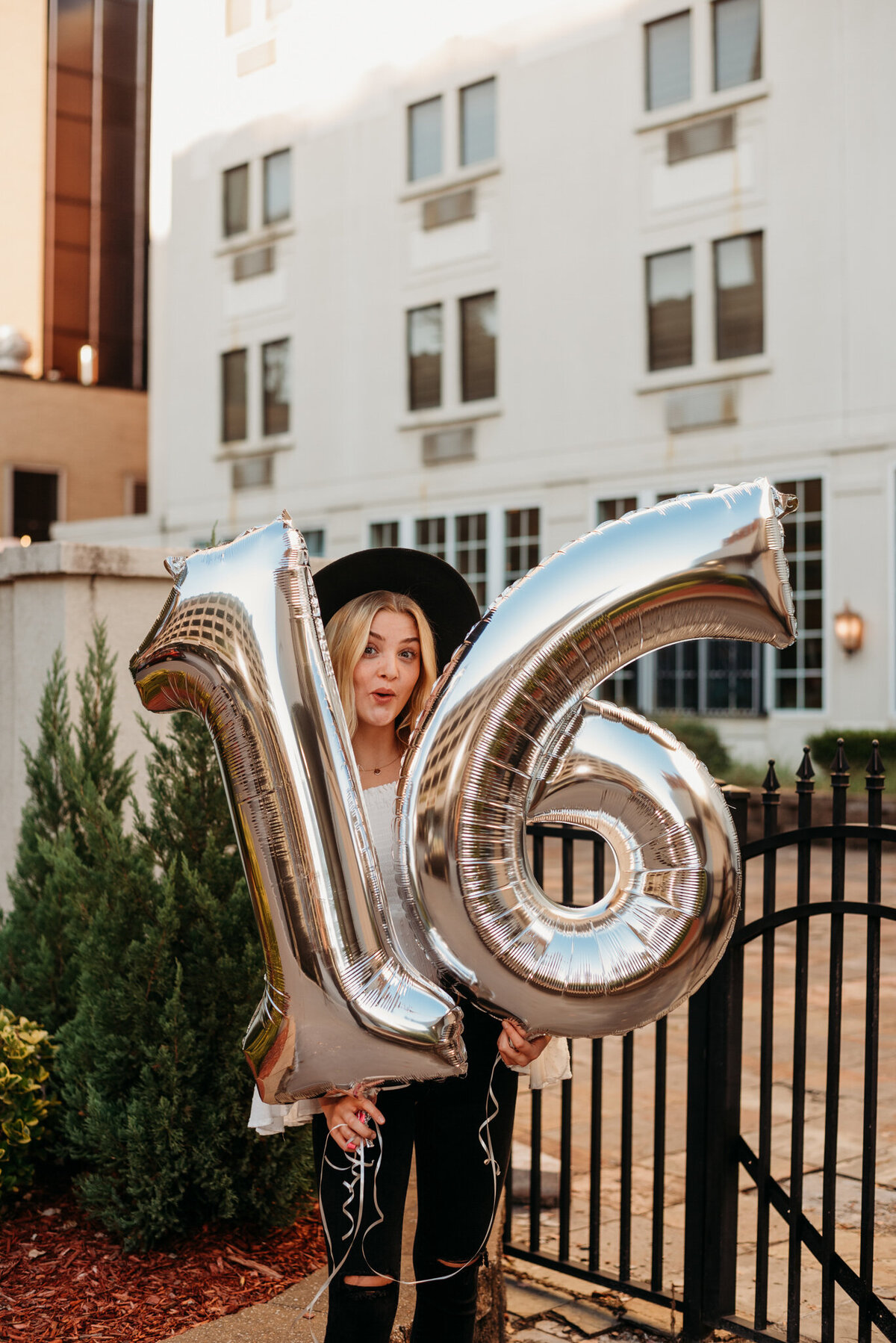 photo of girl holding number balloons
