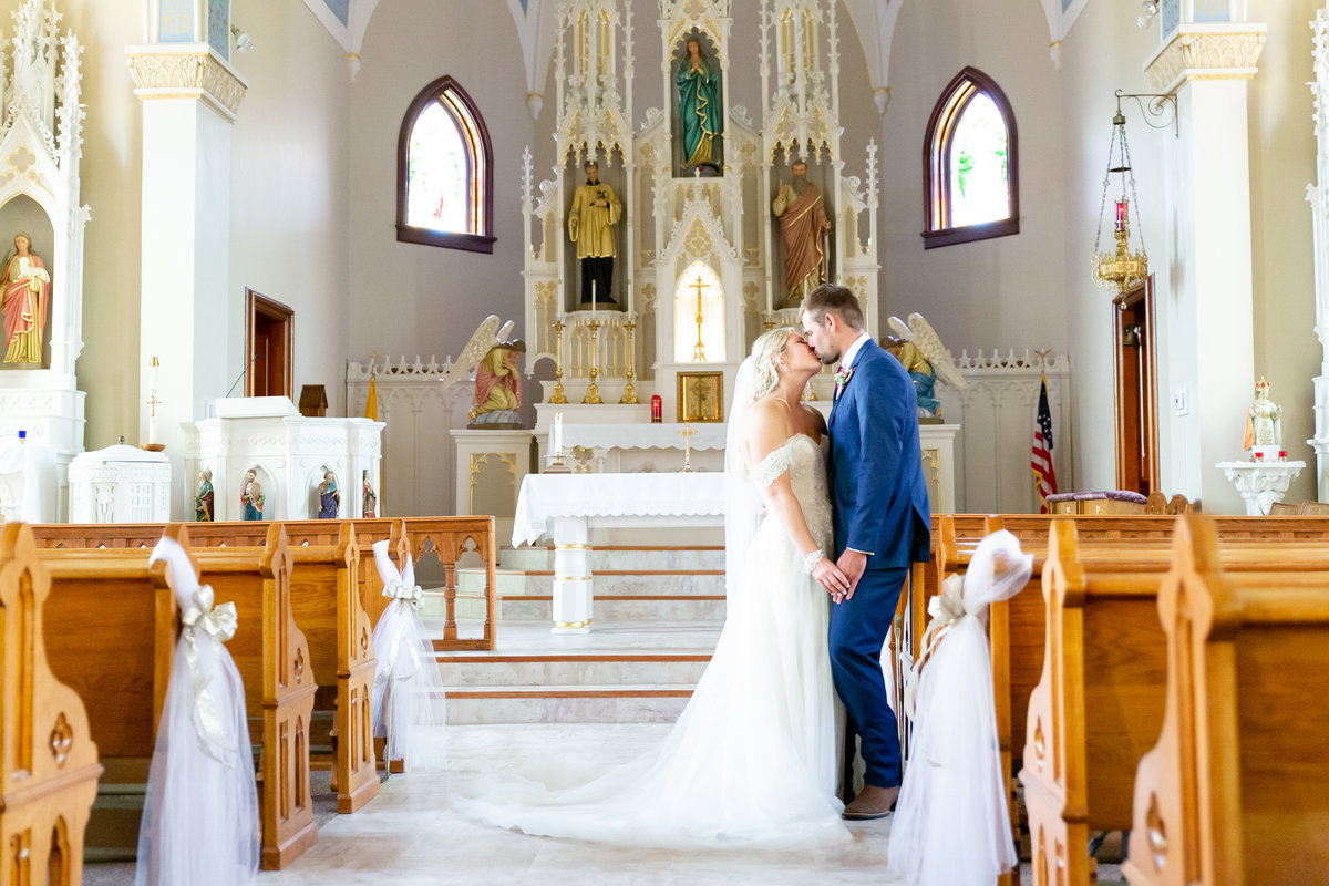 Bride and groom share a kiss on wedding day at Immaculate Conception