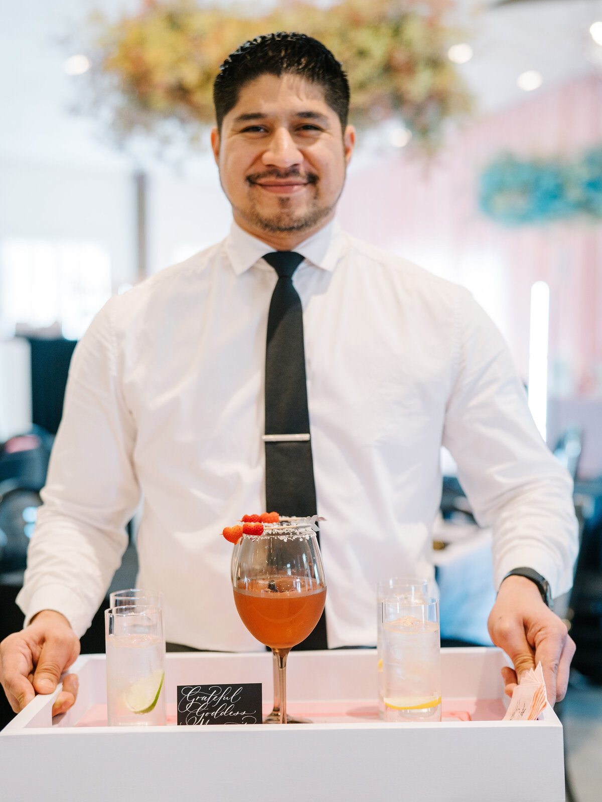 Bartender holding the tray with the drinks and the custom sign calligraphy