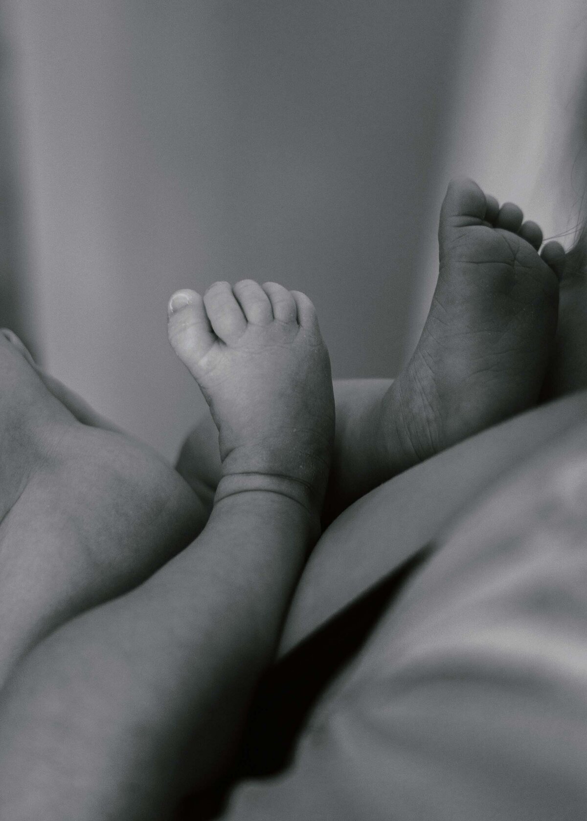 Maddie Rae Photography black and white of babys toes resting on moms chest