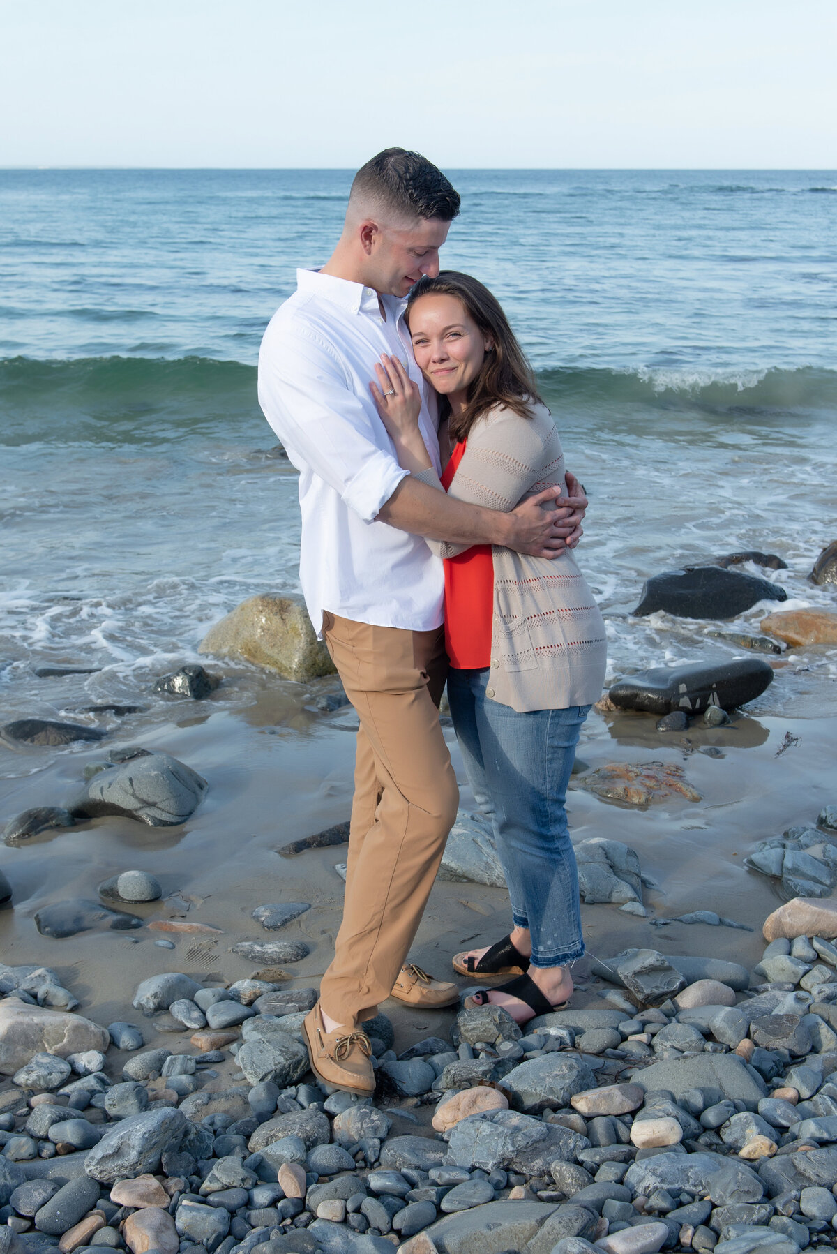 engaged couple huggin on the beach in Ogunquit Maine