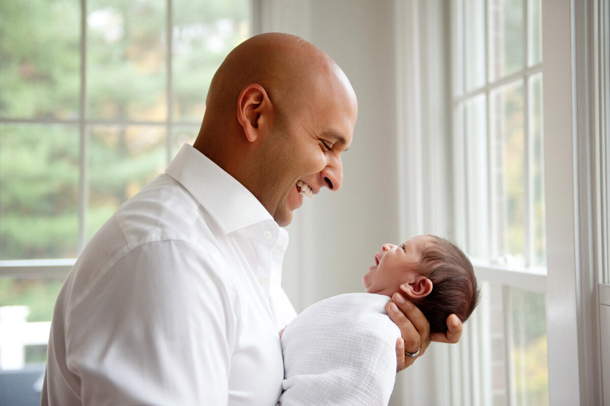 Newborn session of baby and father in home