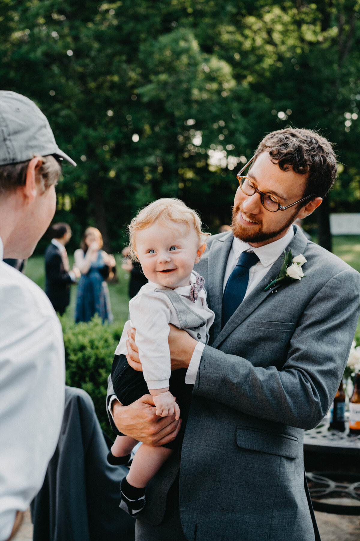 groom with baby during cocktail hour