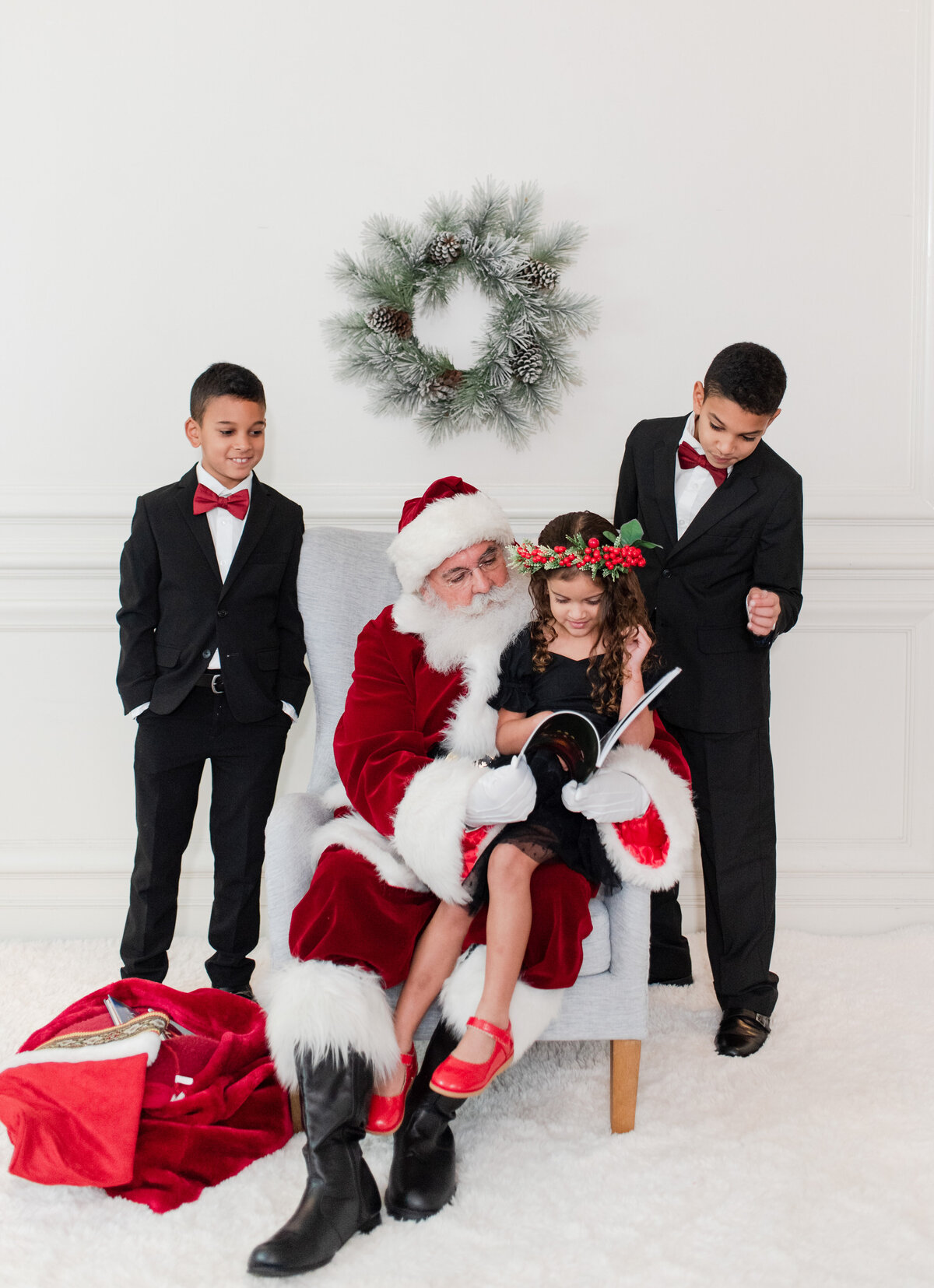 3 siblings reading a book with Santa by Miami Christmas Mini Session Photographer