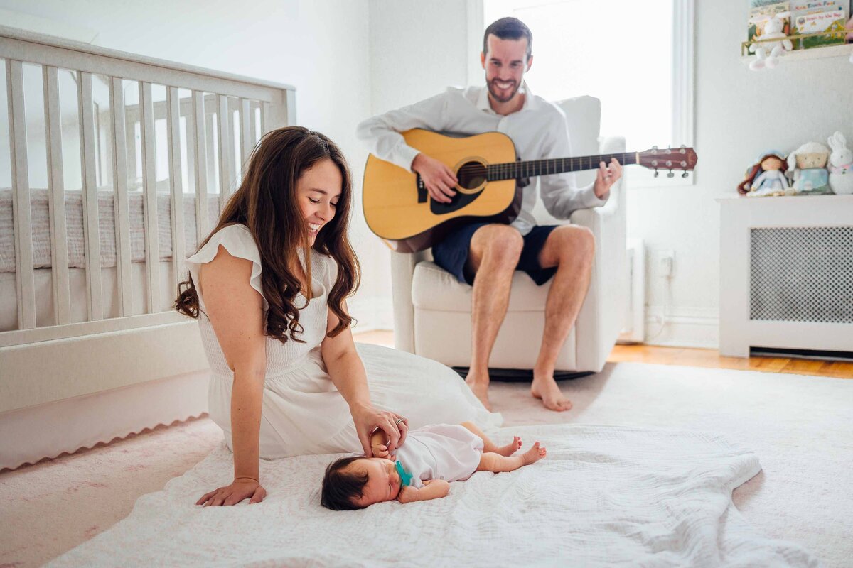 daad playing guitar for mom and newborn baby