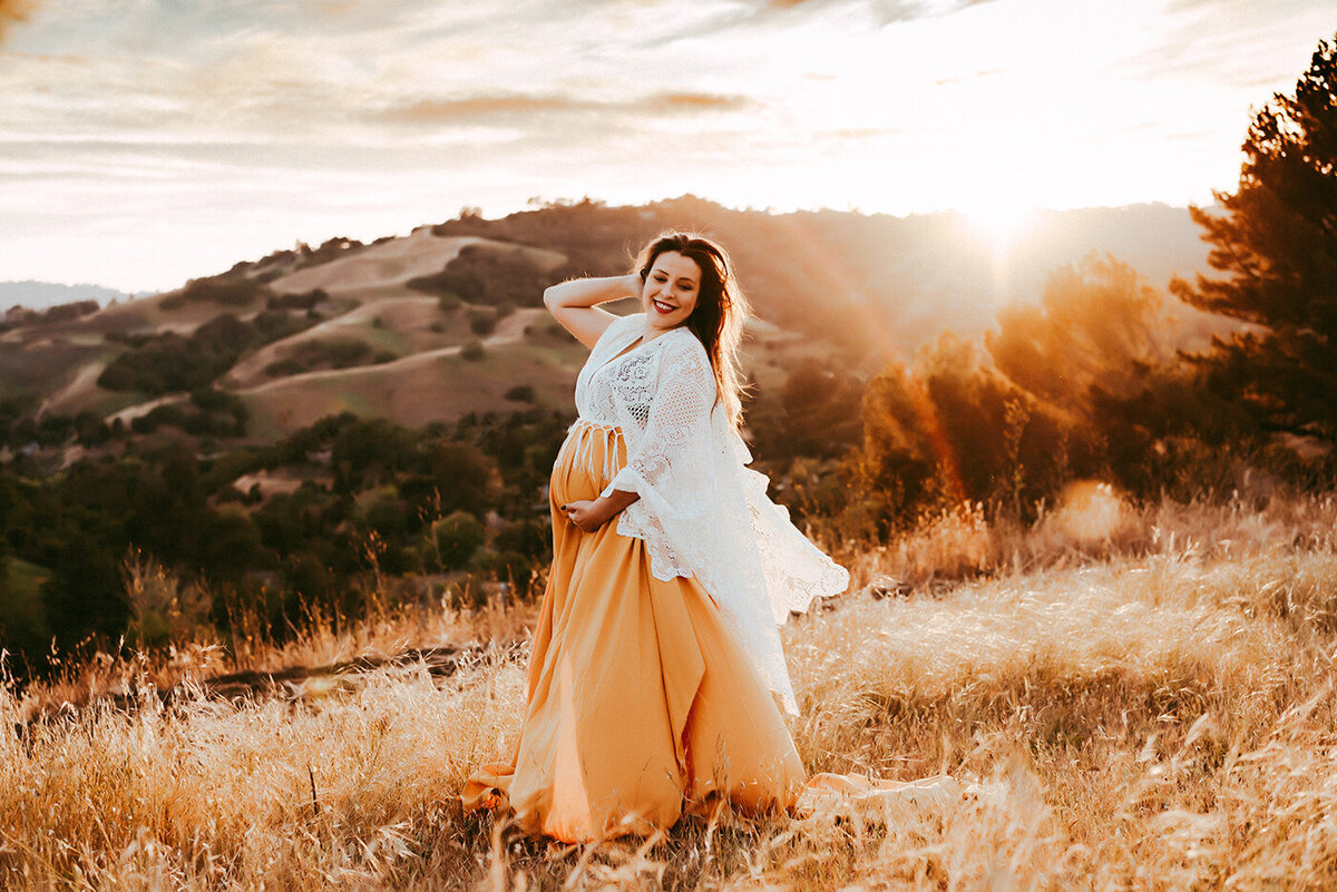 Pregnant mama holding her belly in a beautiful orange and white gown