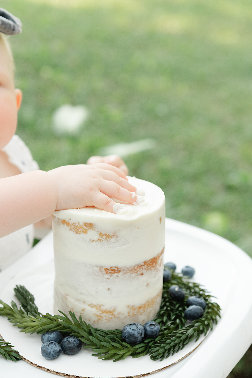 A baby's hand on a smash cake captured by a destin family photographer.