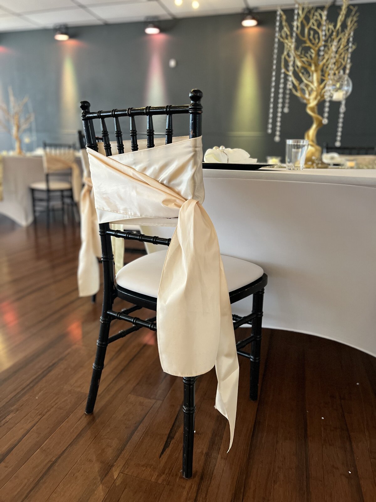 Black Chiavari chair with elegant champagne chair sash, creating a dreamy atmosphere for a Florida wedding - Perfect blend of sophistication and charm