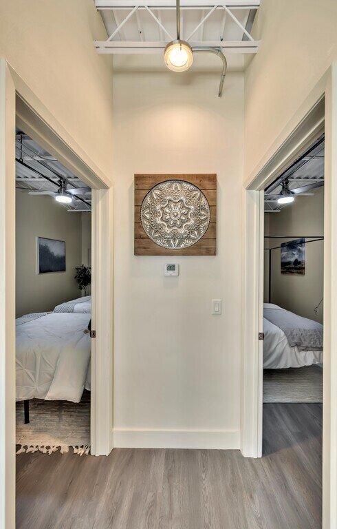 Hallway view of bedrooms with beautiful decor and comfortable beds in this 2 bedroom, 2.5 bathroom luxury vacation rental loft condo for 8 guests with incredible downtown views, free parking, free wifi and professional decor in downtown Waco, TX.