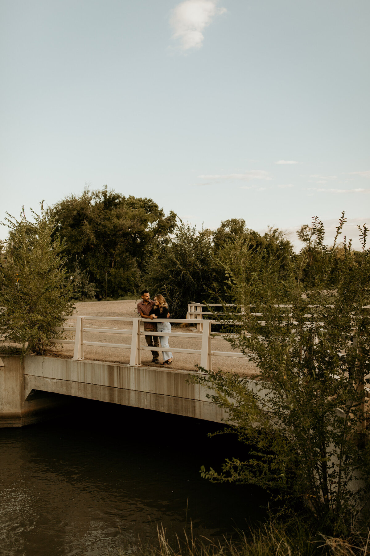 engaged couple standing on a bike bridge in Albuquerque