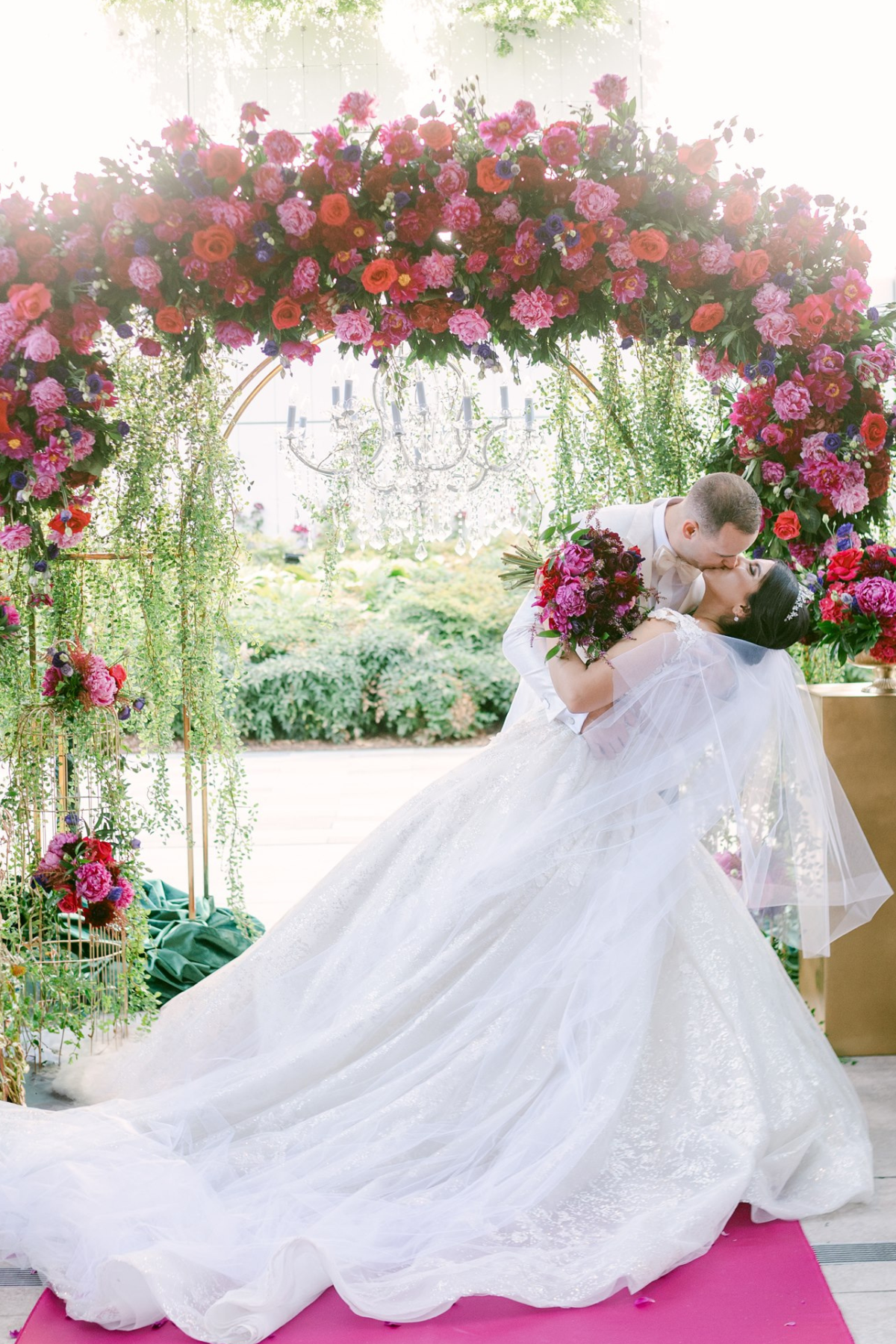 secret-garden-wedding-red-purple-pink-flowers-greenery-arch-bride-groom
