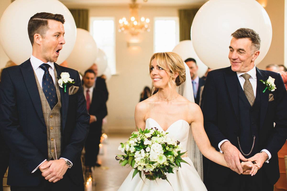 bride walking down the aisle and sees the groom for first time looks surprised