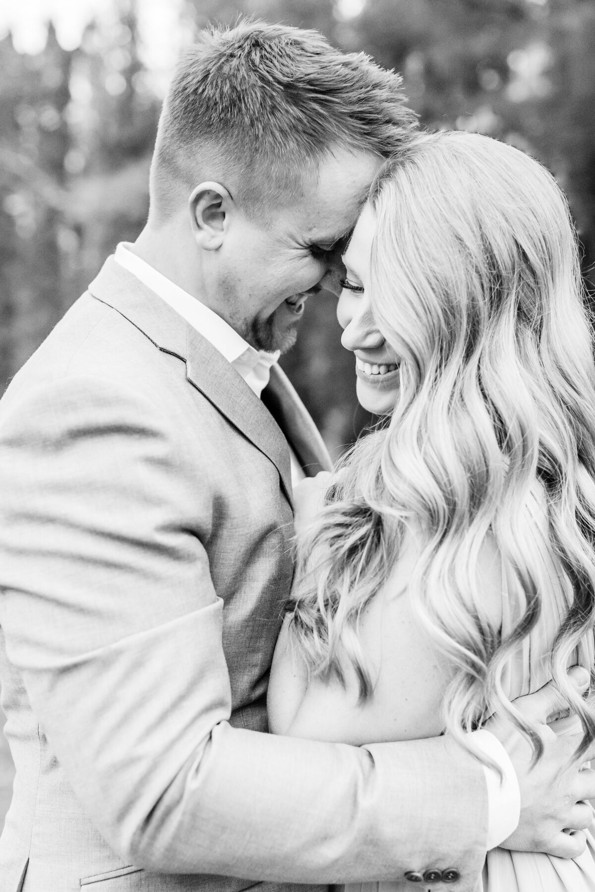 Couple-share-a-special-moment-laughing-as-his-forehead-is-on-her-temple-during-their-fall-engagement-session-at-Cranberry-Creek-Gardens