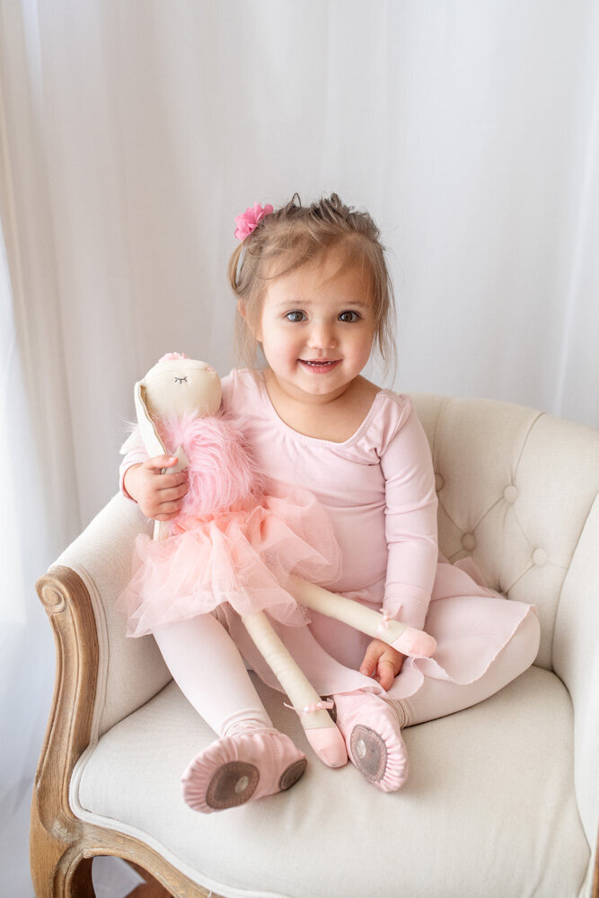 Family session of little girl in pink sitting on a chair