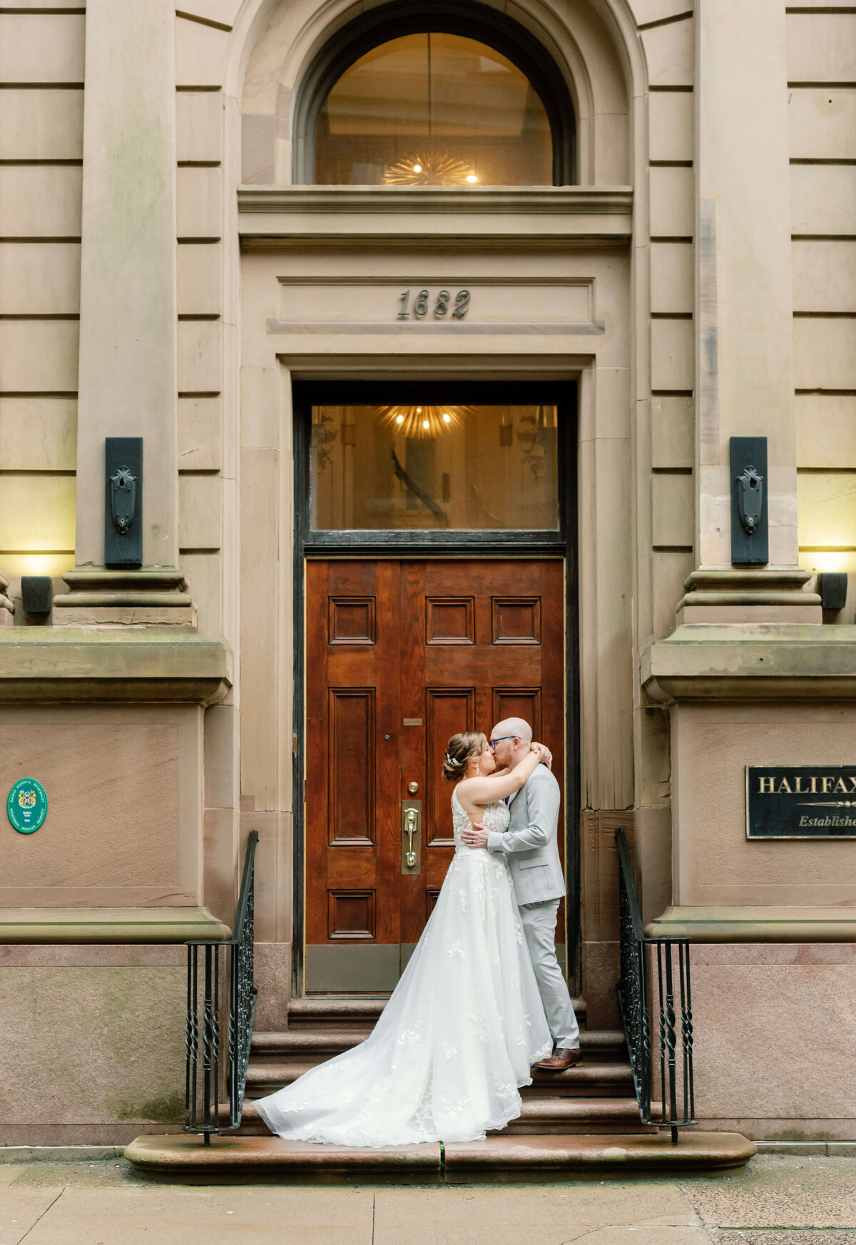 Bride and groom kissing outside a large door at  at Halifax Club wedding in Nova Scotia