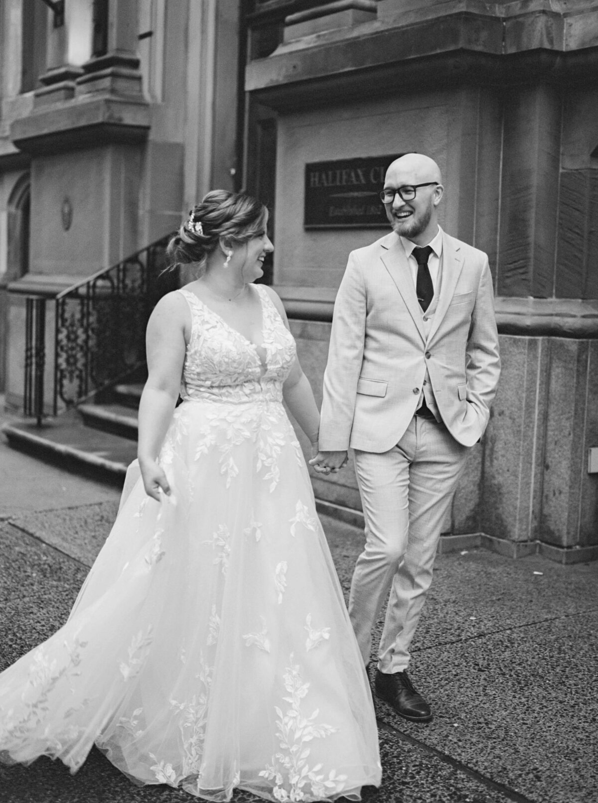 Bride and groom walking along holding hands at  at Halifax Club wedding in Nova Scotia