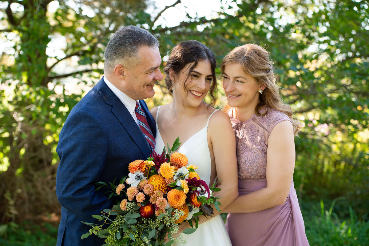family formals of a bride, her mother and father taken outside in the fall at Strathmere wedding venue.  Captured by Ottawa wedding photographer JEMMAN Photography