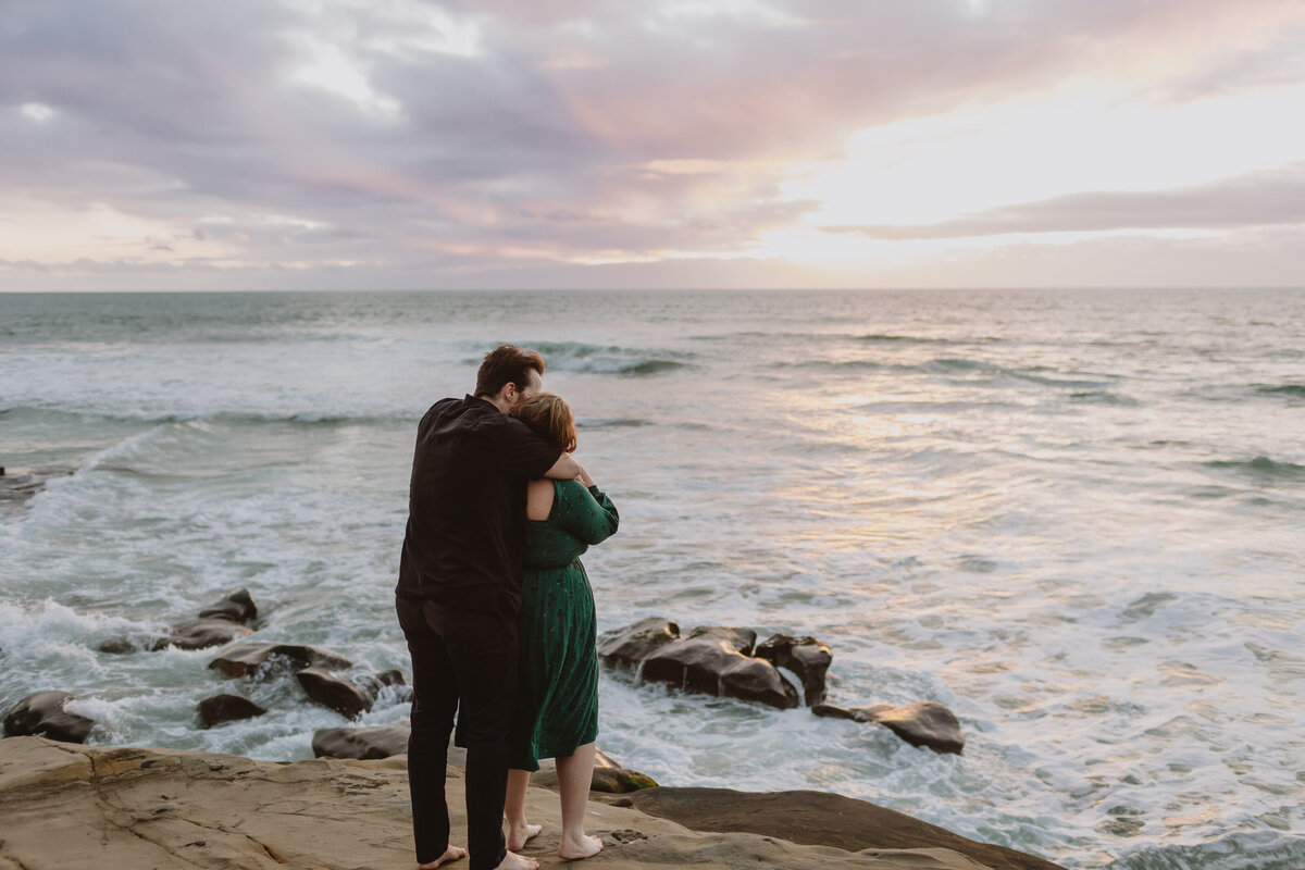 Couple facing an ocean sunset