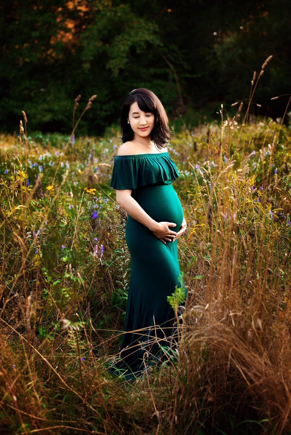 Maternity photoshoot outdoors with woman wearing green Chicaboo Harper gown in Jericho Beach Park field