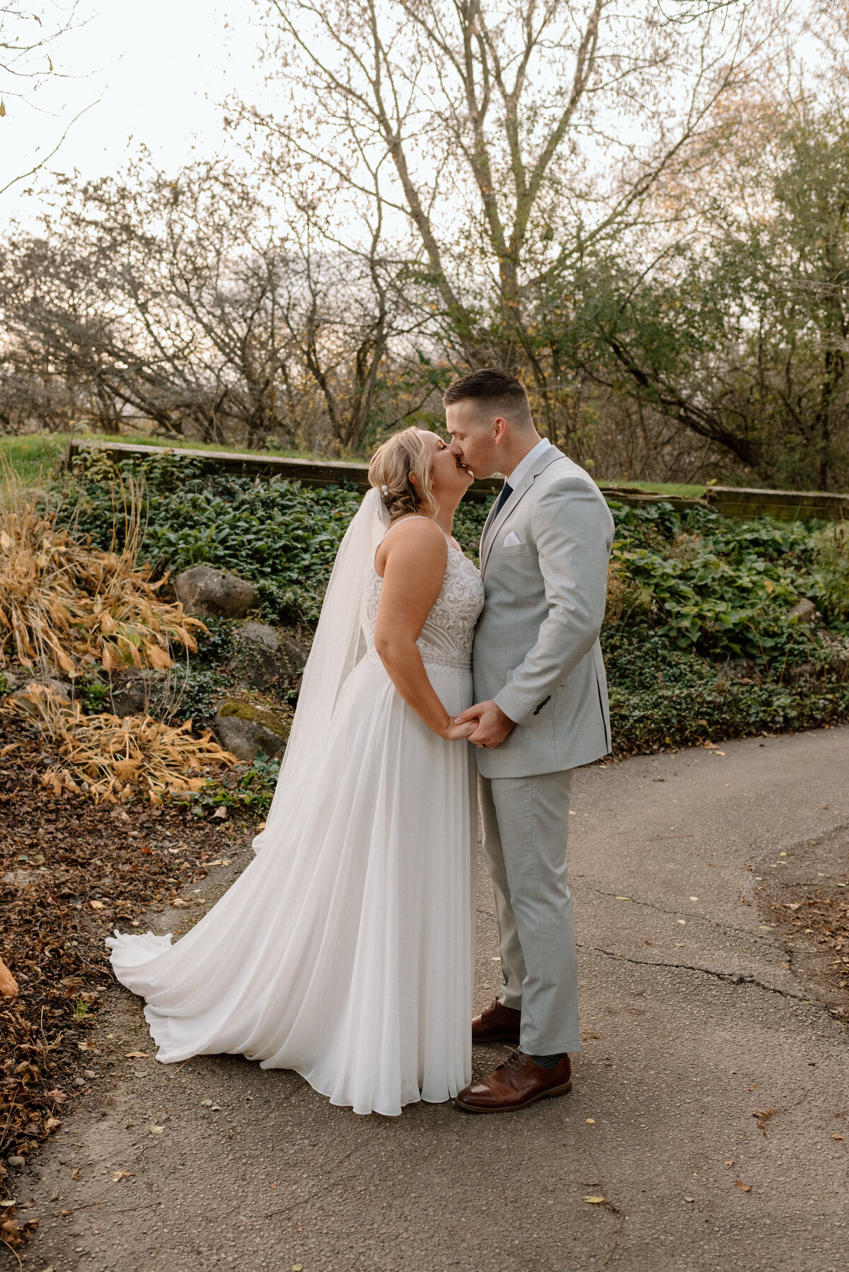 bride and groom kissing on the golf course path
