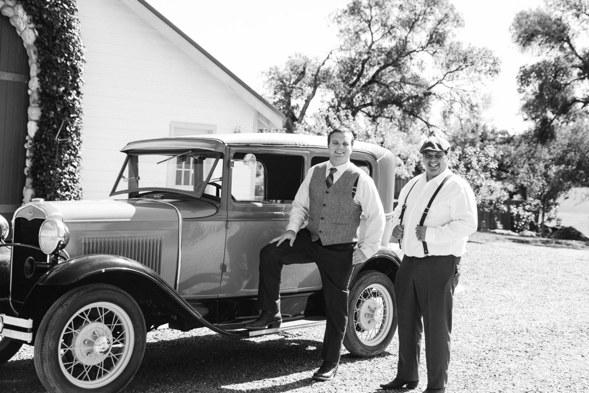 Groom with classic car on wedding day