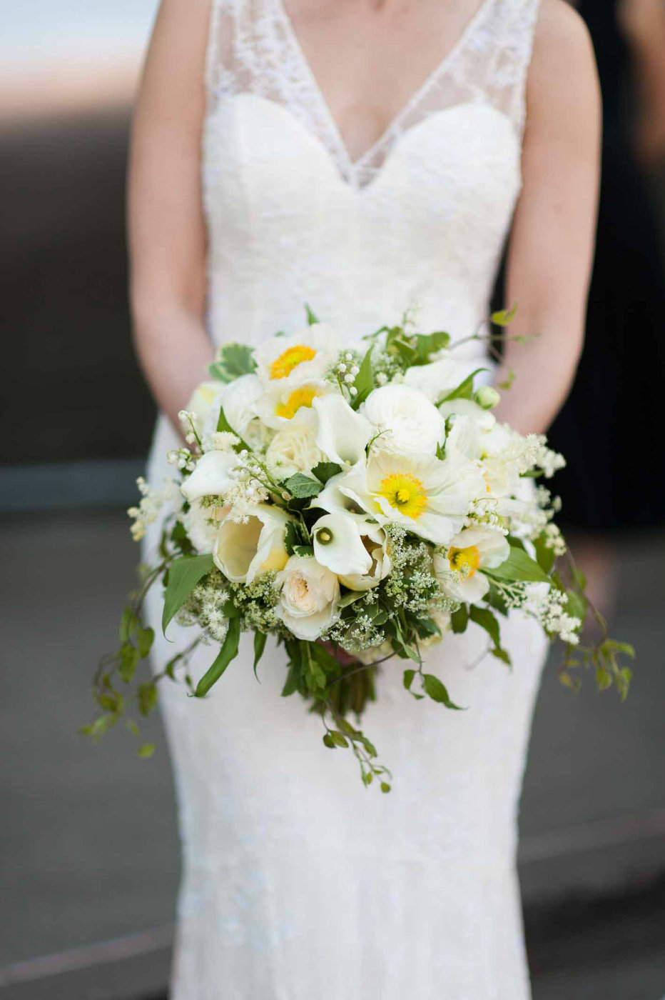 Elegant spring bridal bouquet in whites, yellows, and green featuring poppies and lily of the valley.