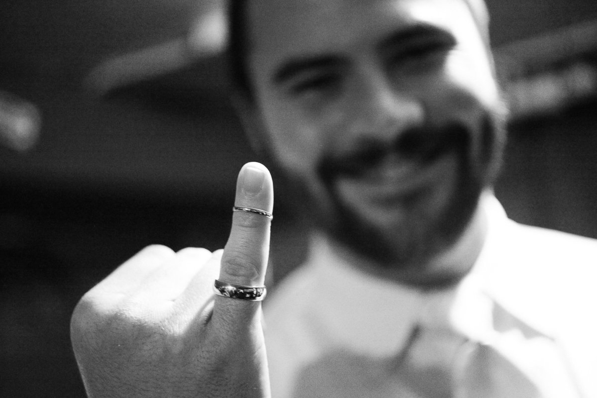 A groom shows off the wedding rings.