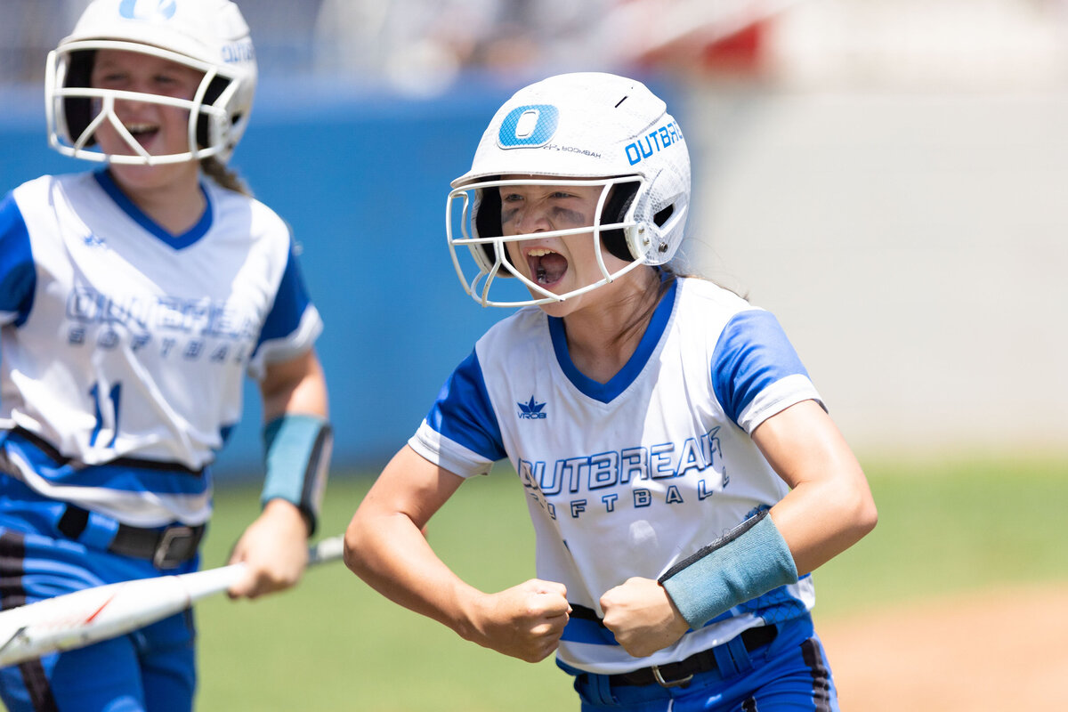 A team outbreak player flexes to her teammates after scoring a run during the USSSA World Series.