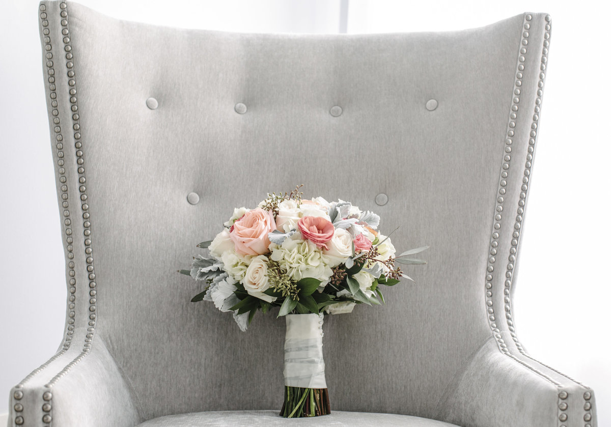 brides boutique resting on grey chair before wedding