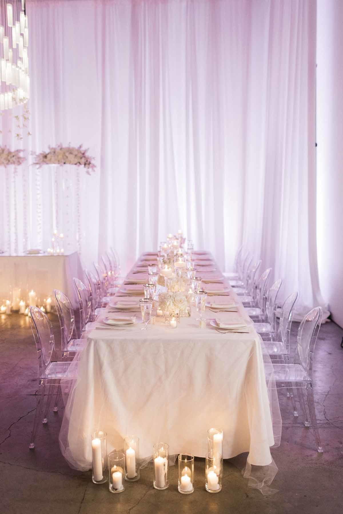 These beautiful long white tables with ghost chairs designed by Flora Nova Design make for a stunning wedding reception.