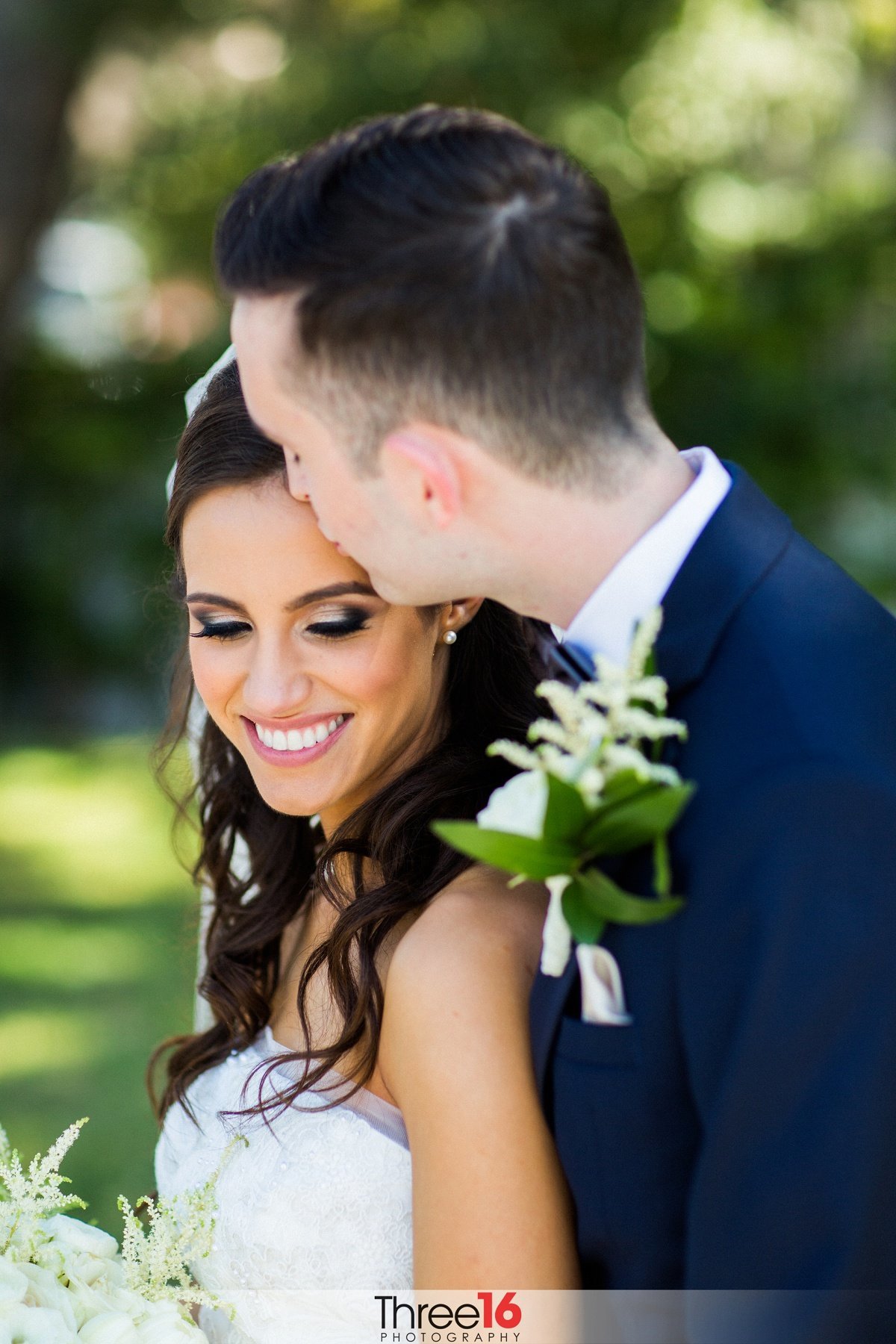 Groom kisses his Bride's head as he holds her close from behind