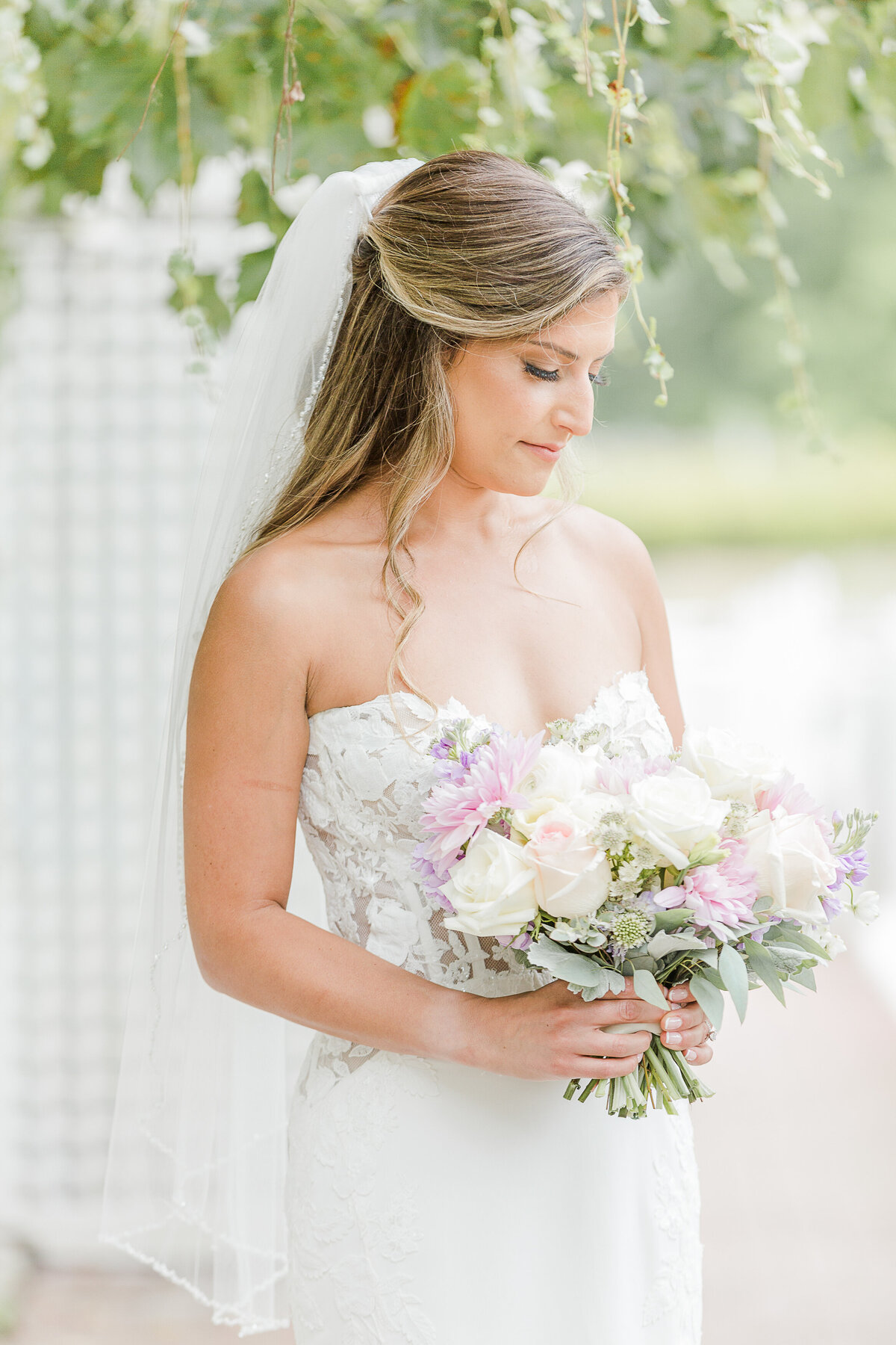 Formal bridal portrait. A bride is looking down at her bouquet. Captured by best Massachusetts wedding photographer Lia Rose Weddings.