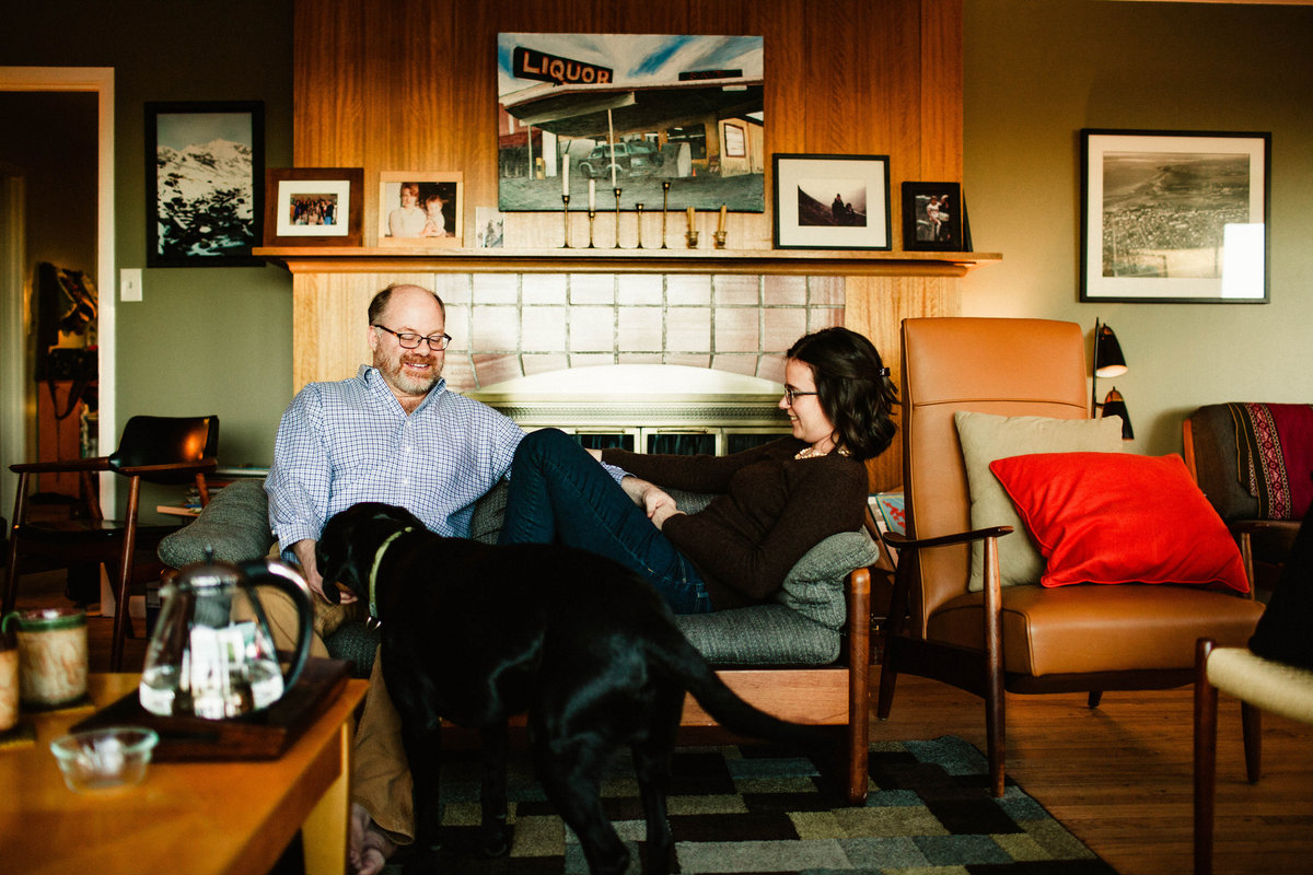 husband and wife sitting on couch in midcentury modern living room