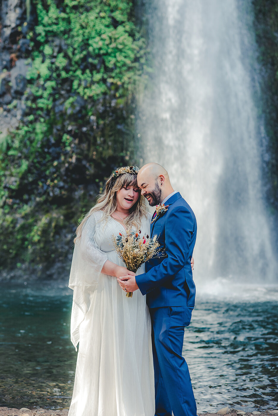 bride and groom by waterfall