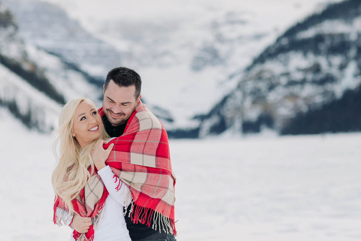lake louise winter couples photos cuddle red plaid blanket