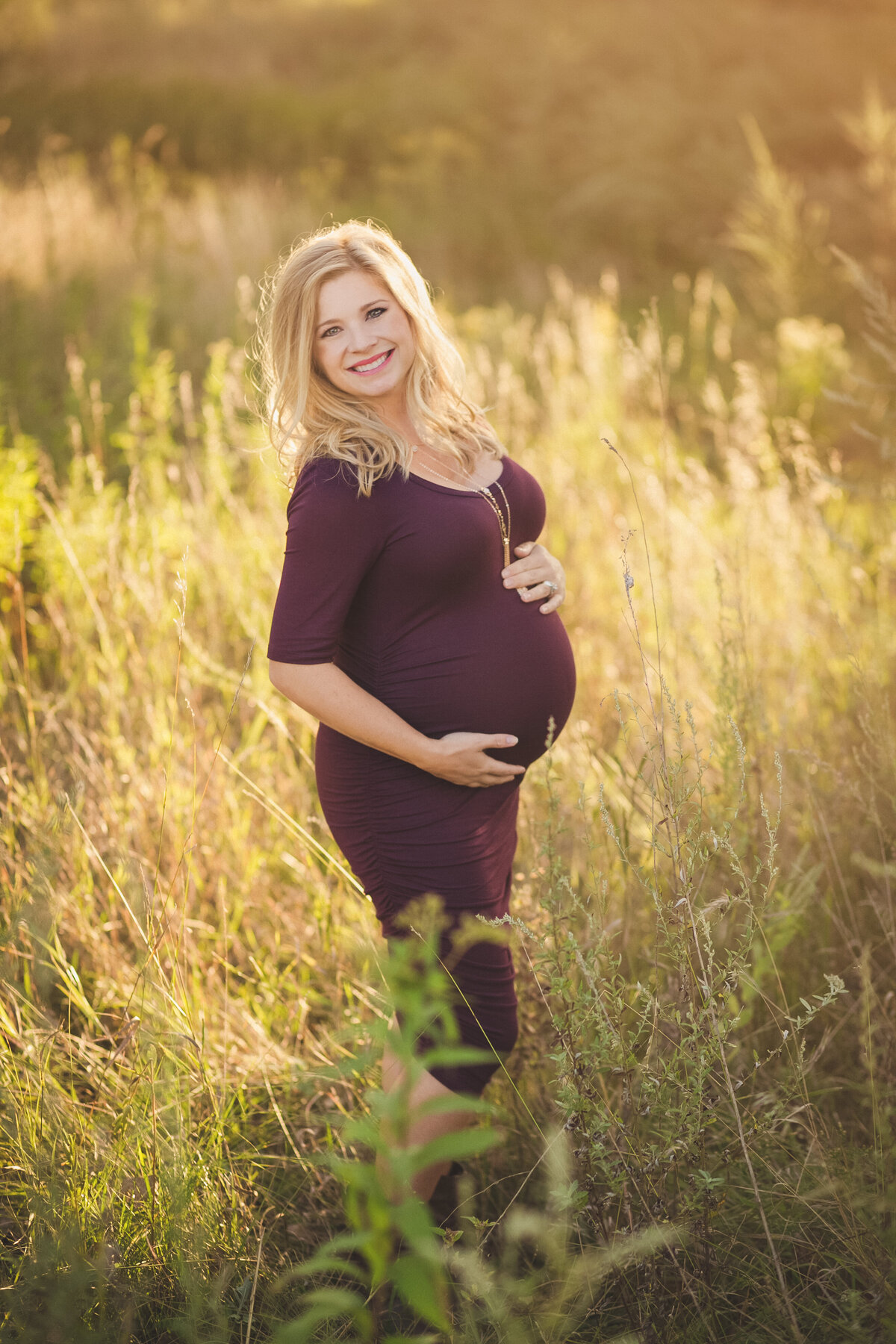 pregnant woman in purple dress in field