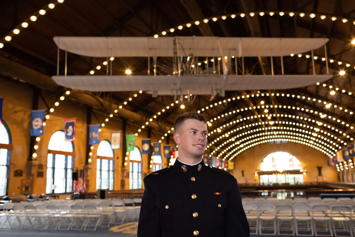 Marine officer senior portrait in Annapolis, Maryland at the Naval Academy Dahlgren Hall with lights and wright flyer.
