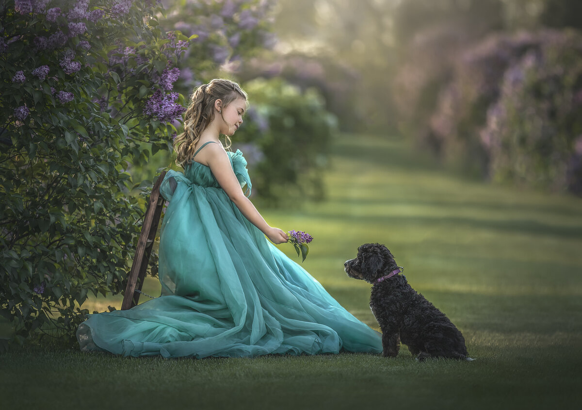 award winning photograher sonia Gourlie takes photo of young girl and her puppy in the lilacs in Ottawa Ontario