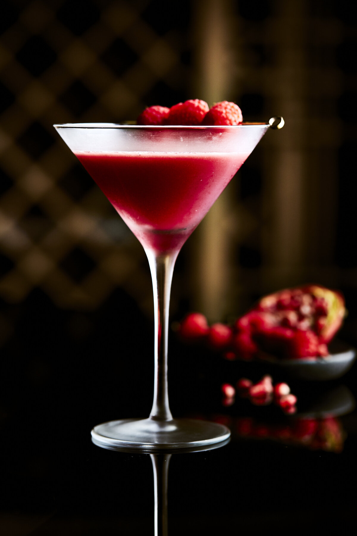 A martini glass with a cocktail topped with berries.