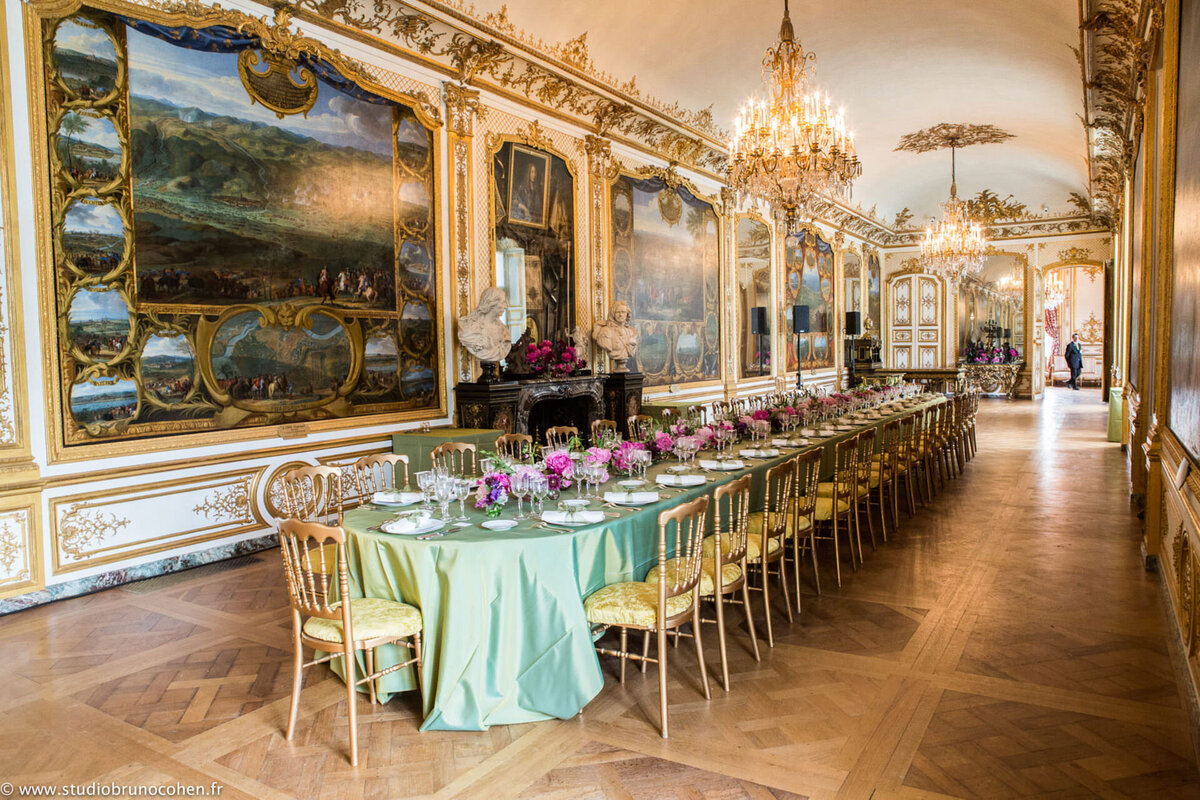 Table set with green tablecloth and purple flowers at Château de Chantilly